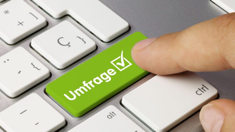Ein Zeigefinger drückt auf einer Tastatur auf eine grüne Taste mit der Aufschrift 